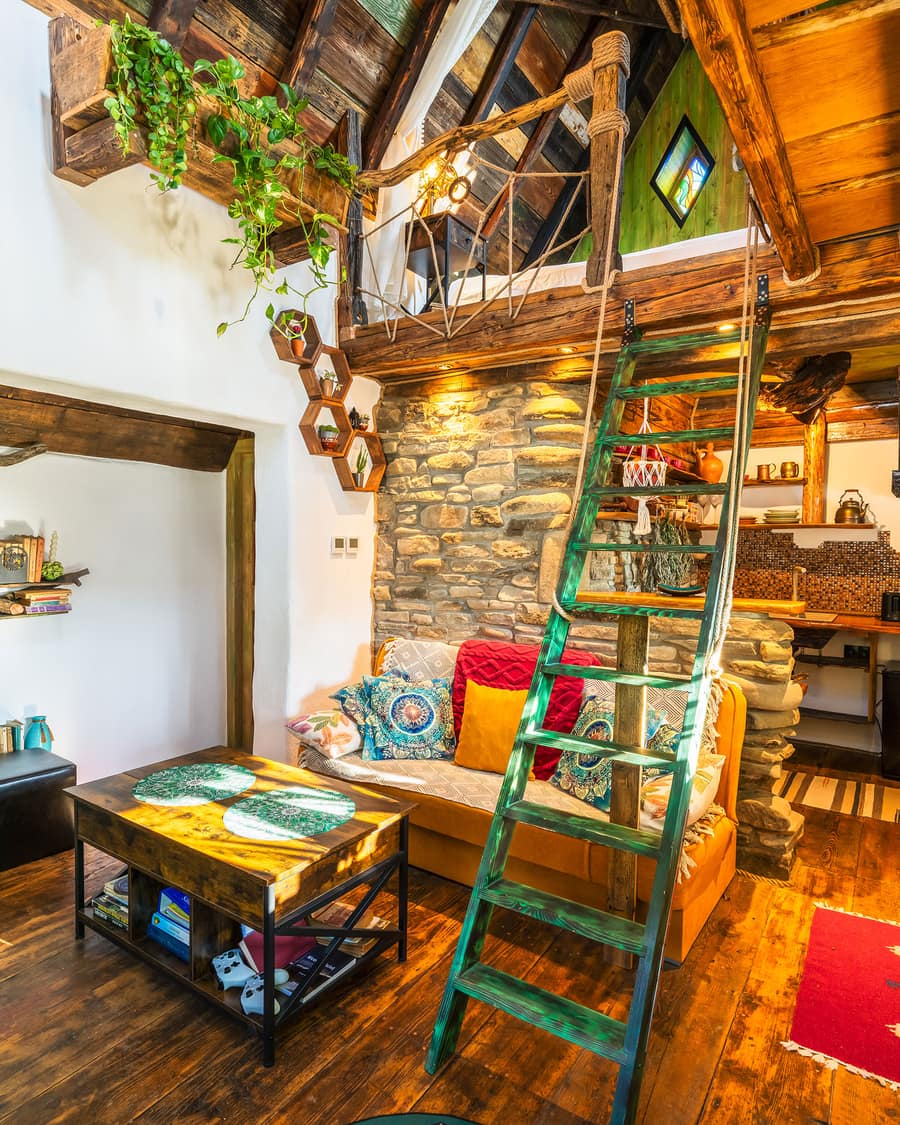 Inside the loft — green ladder, stone fireplace and a reading nook